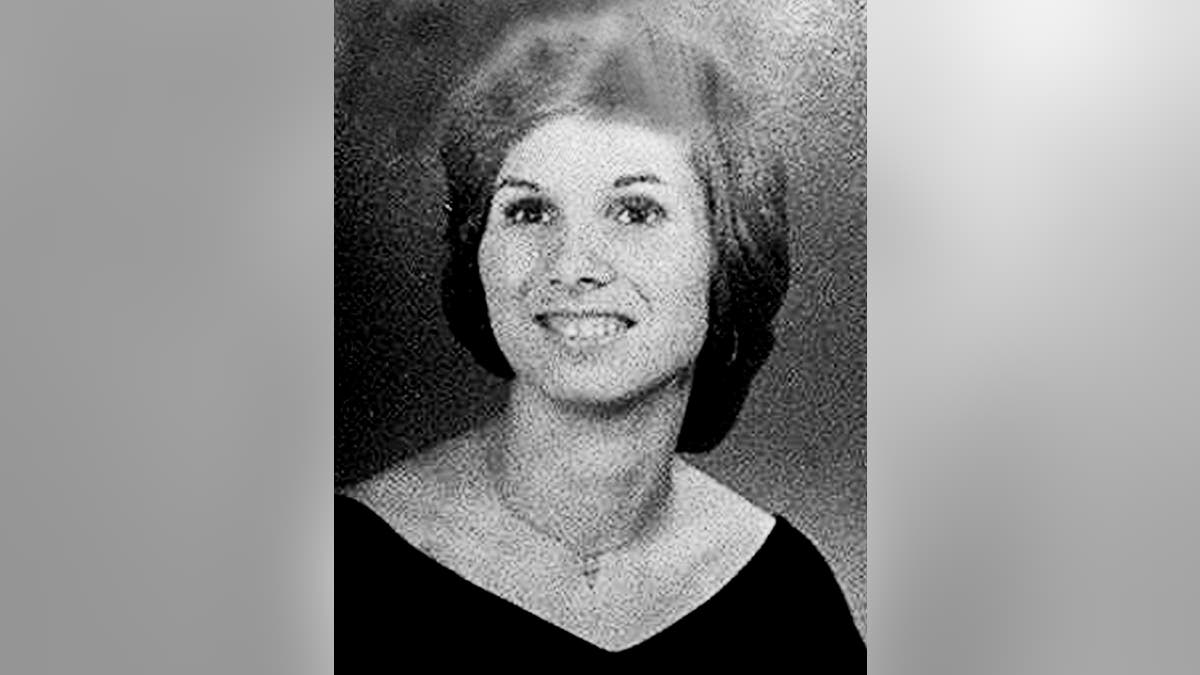 A black and white photo of Donna Lauria smiling in a black dress.