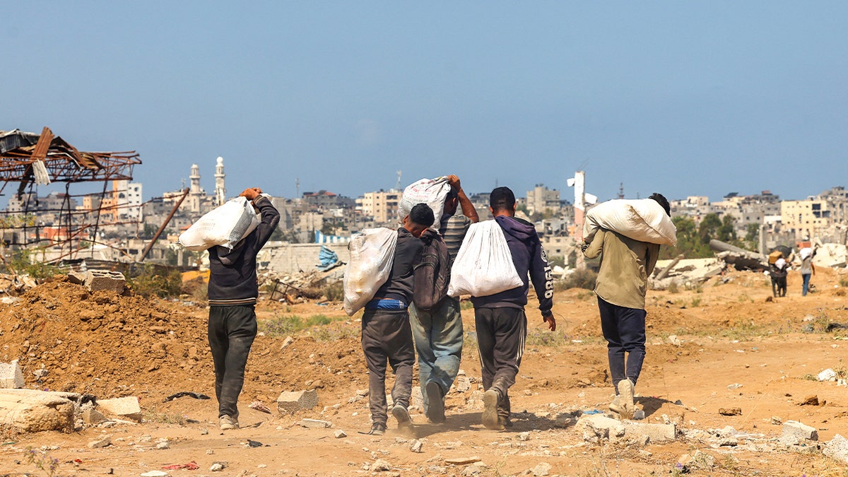 Palestinians carry bags of aid