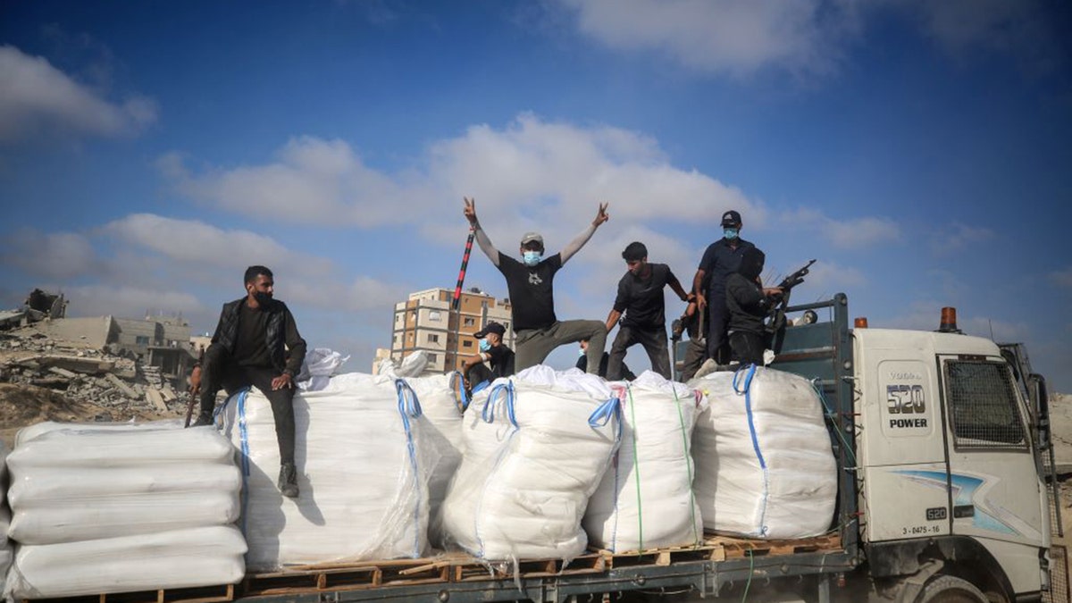 Hamas terrorists carrying clubs and firearms secure humanitarian aid trucks in the northern Gaza area of Jabaliya on June 25, 2025.