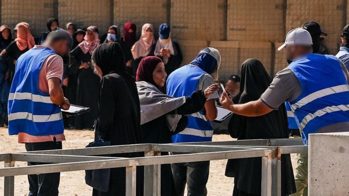 Women engage with Gaza Humanitarian Foundation (GHF) workers. 