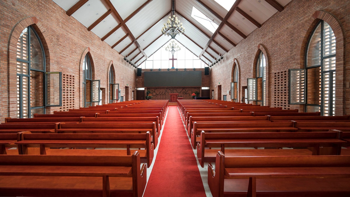 The inside of a church with seats and pews. 