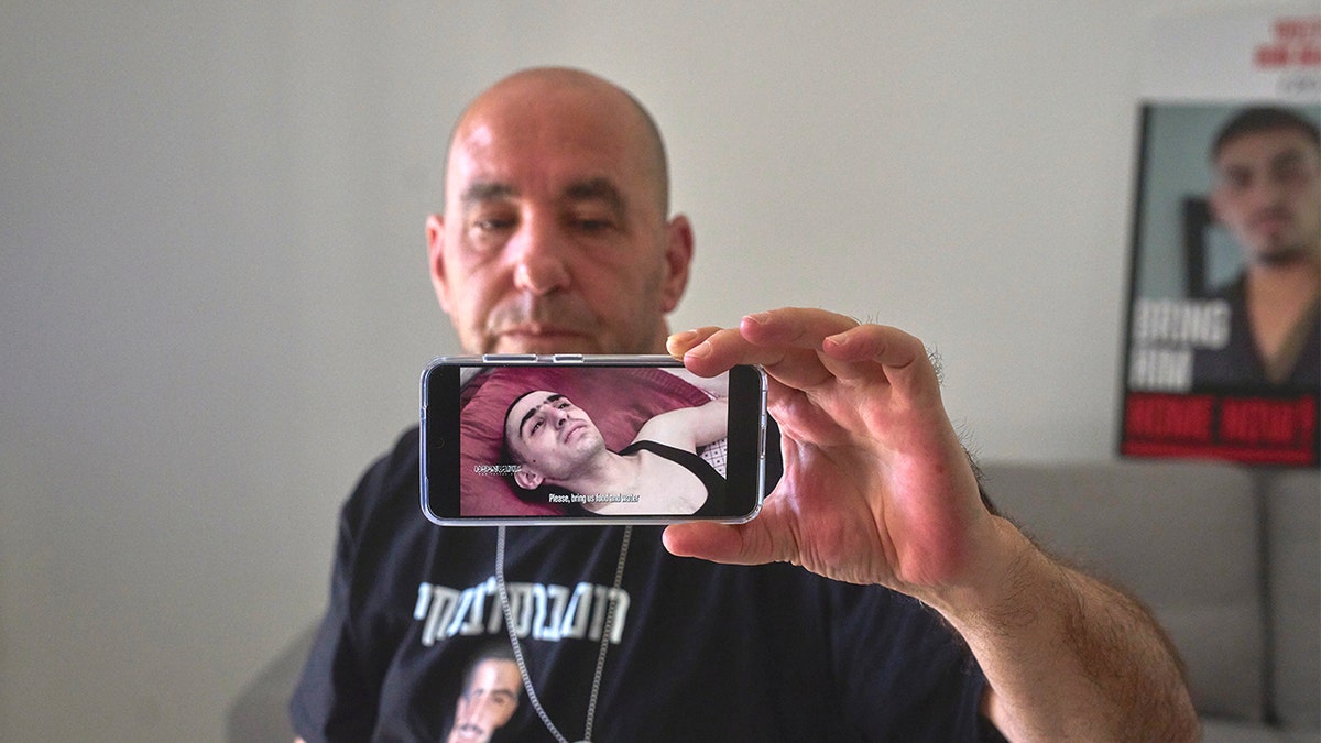 Ofir Braslavski shows a video from terrorist group Palestinian Islamic Jihad, published last week of his son Rom, gaunt and emaciated in captivity in Gaza.