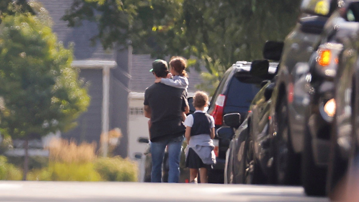 Guardian with student after a mass shooting at a catholic school.