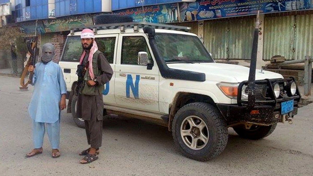 Sept. 29, 2015: Taliban fighters pose for a photo next to a UN vehicle they plundered in Kunduz, Afghanistan.