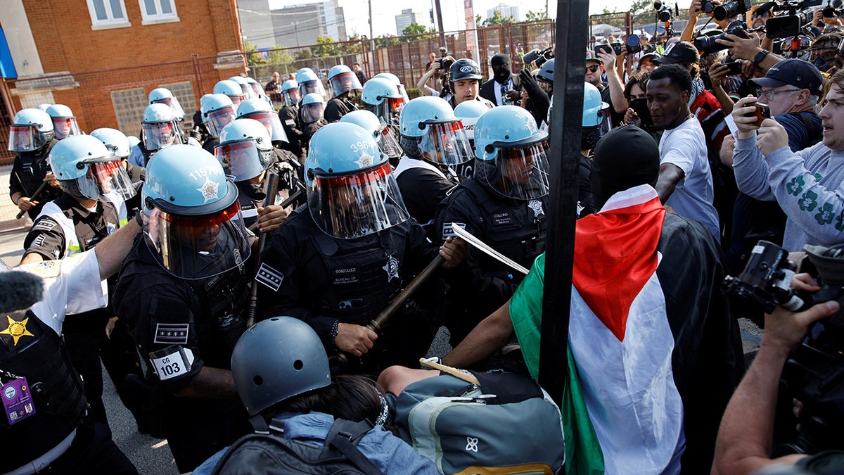 Riot police officers scuffle with demonstrators during the rally "March on the DNC" on the sidelines of the Democratic National Convention