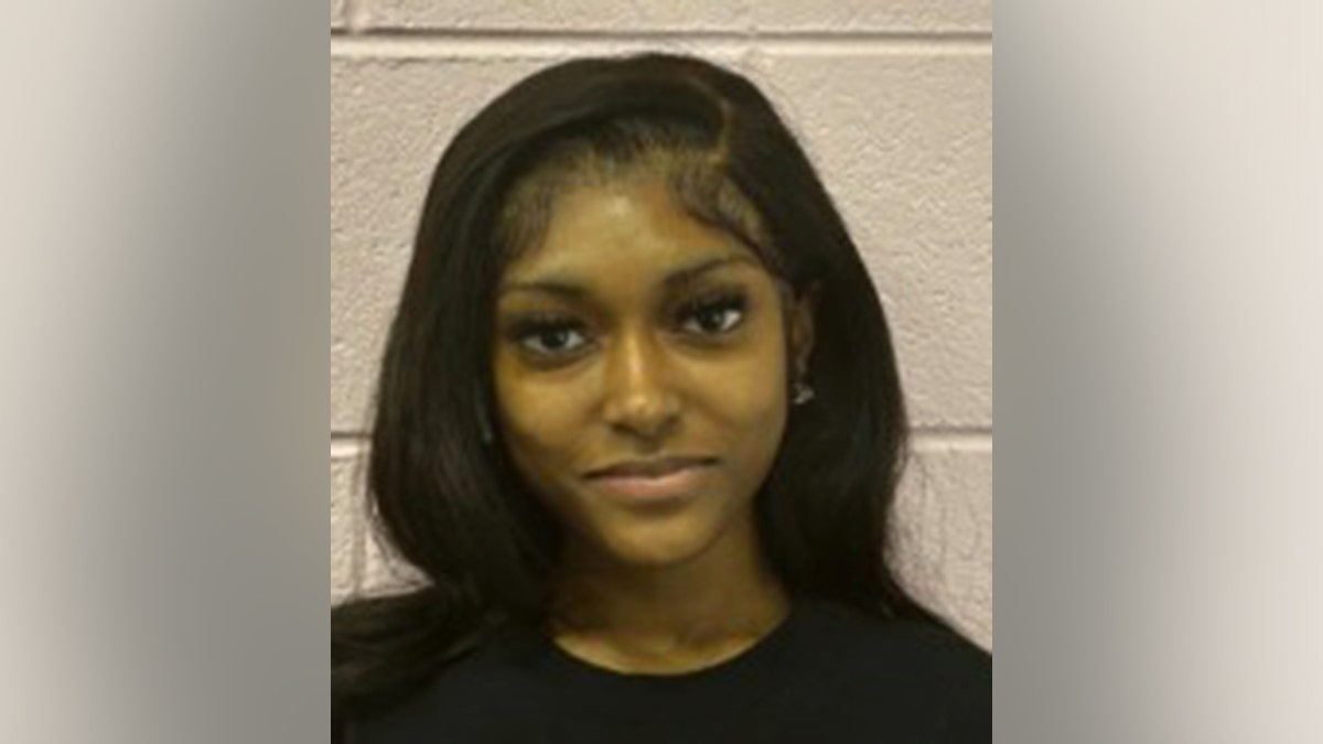 Dacara Thompson in black shirt standing against a wall