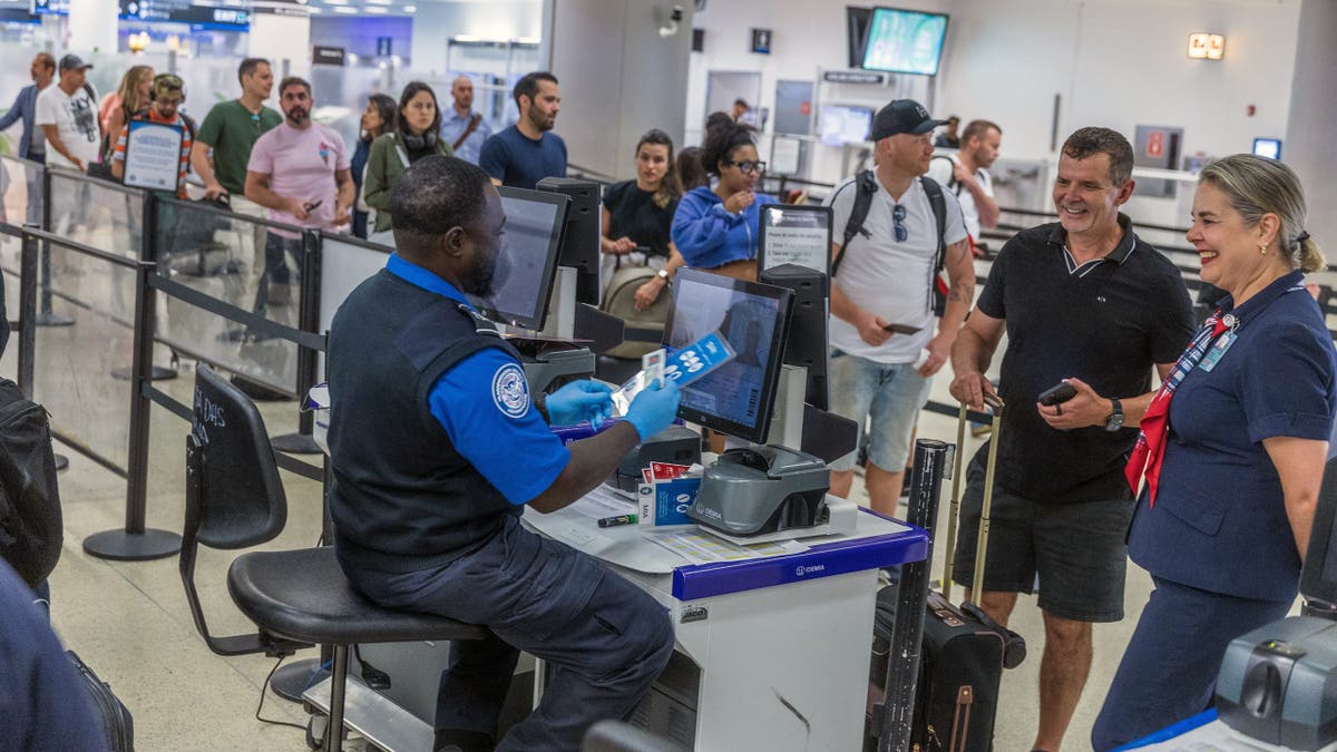 TSA agents verify passengers identities on a checkpoint at Miami International Airport.