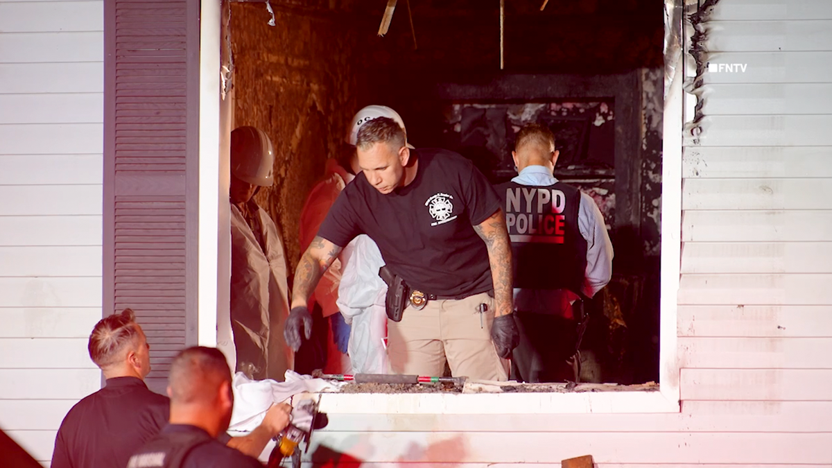 a still image taken from video shows a member of law enforcement handing a battery-powered saw to one of the investigators inside the home