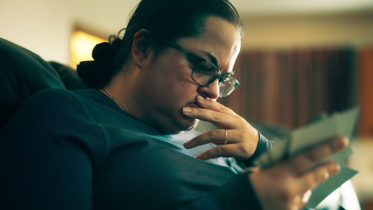 Kerry Rawson looking down and reading something appearing as if she's going to get sick.