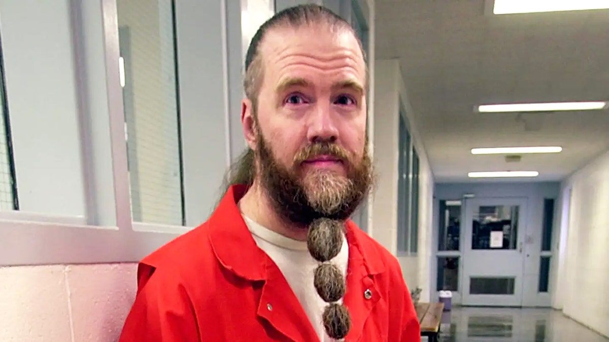 A close-up of Dan Lafferty in an orange jumpsuit.