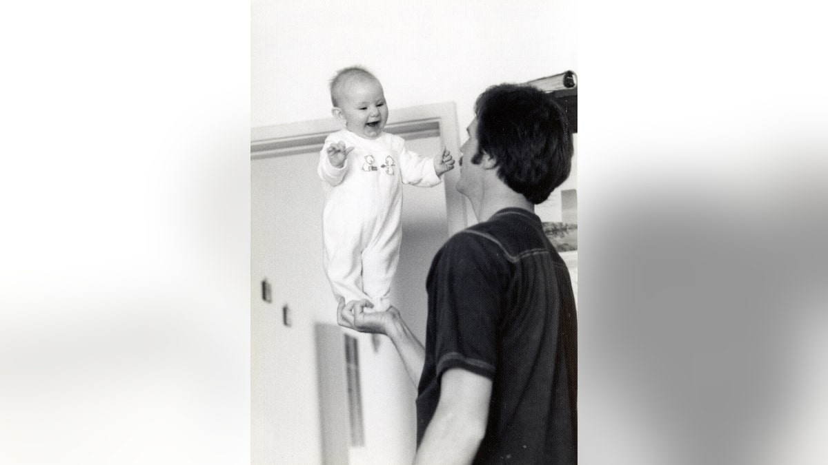 Dan Lafferty holding up baby Rebecca Lafferty.