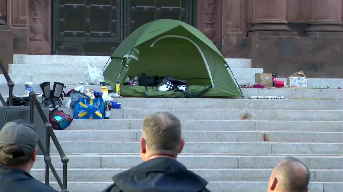 investigators looking at green tent on steps of Cathedral