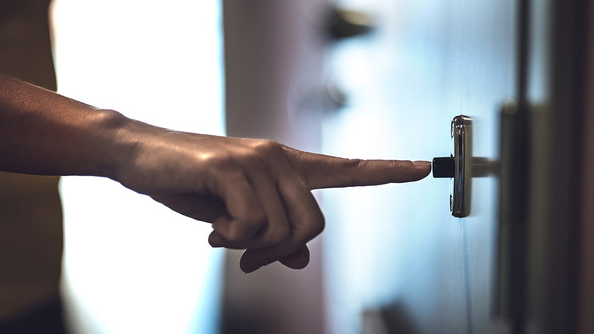 A person ringing a doorbell