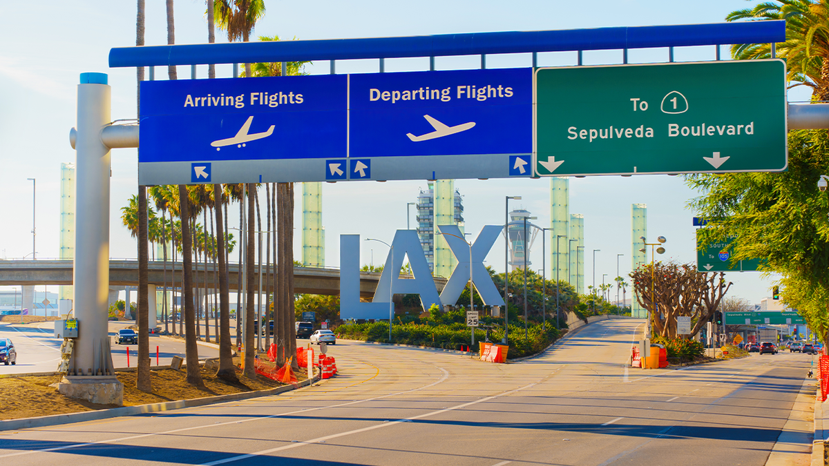 signs for arrivign and departing flights at the entrance of LAX airport in los angeles
