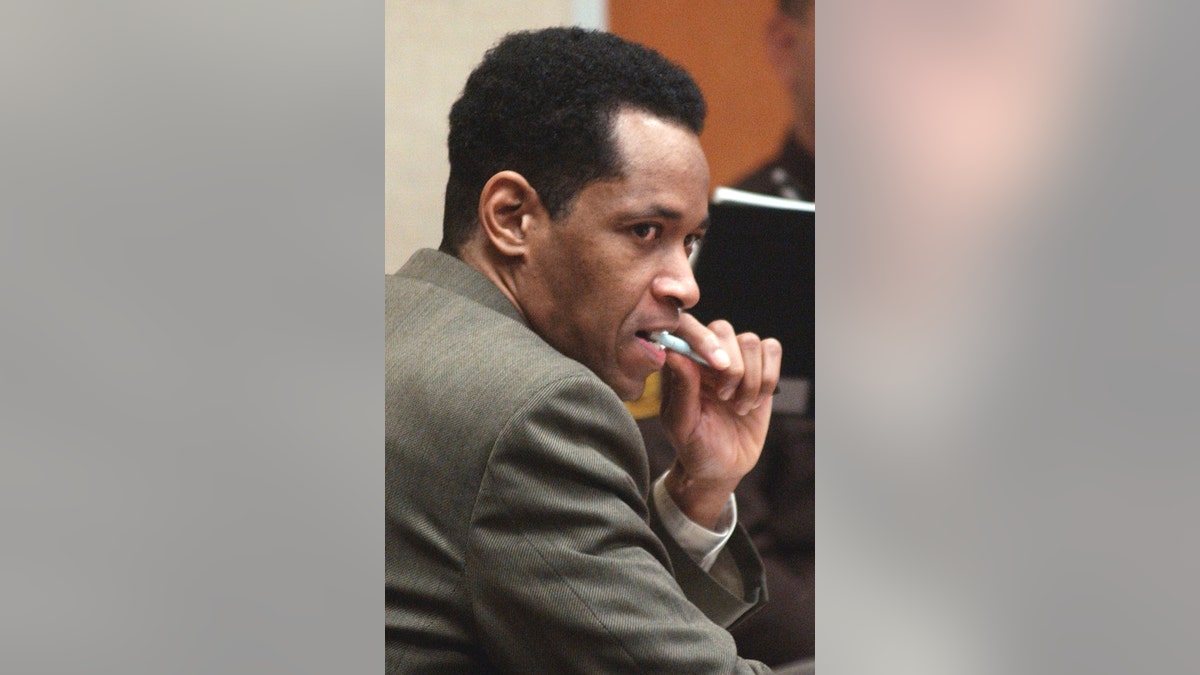 John Allen Muhammad with a pen in his mouth looking sinister.