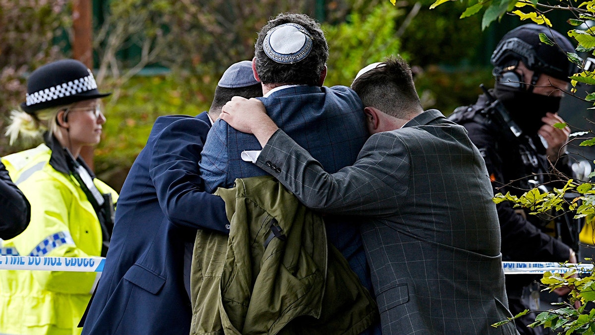 People hug after the attack on a Manchester synagogue