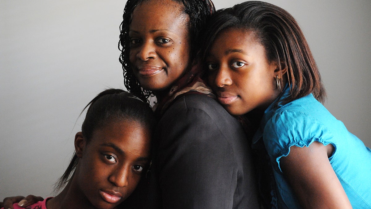 Mildred Muhammad smiling with her two daughters.