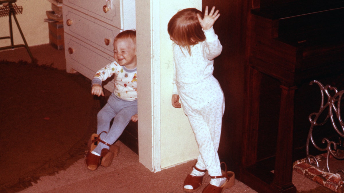 Rebecca Lafferty is seen here playing with her brother as they wear their mother's shoes.