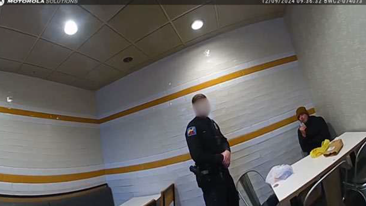 A man identified as Luigi Mangione questioned by a police officer