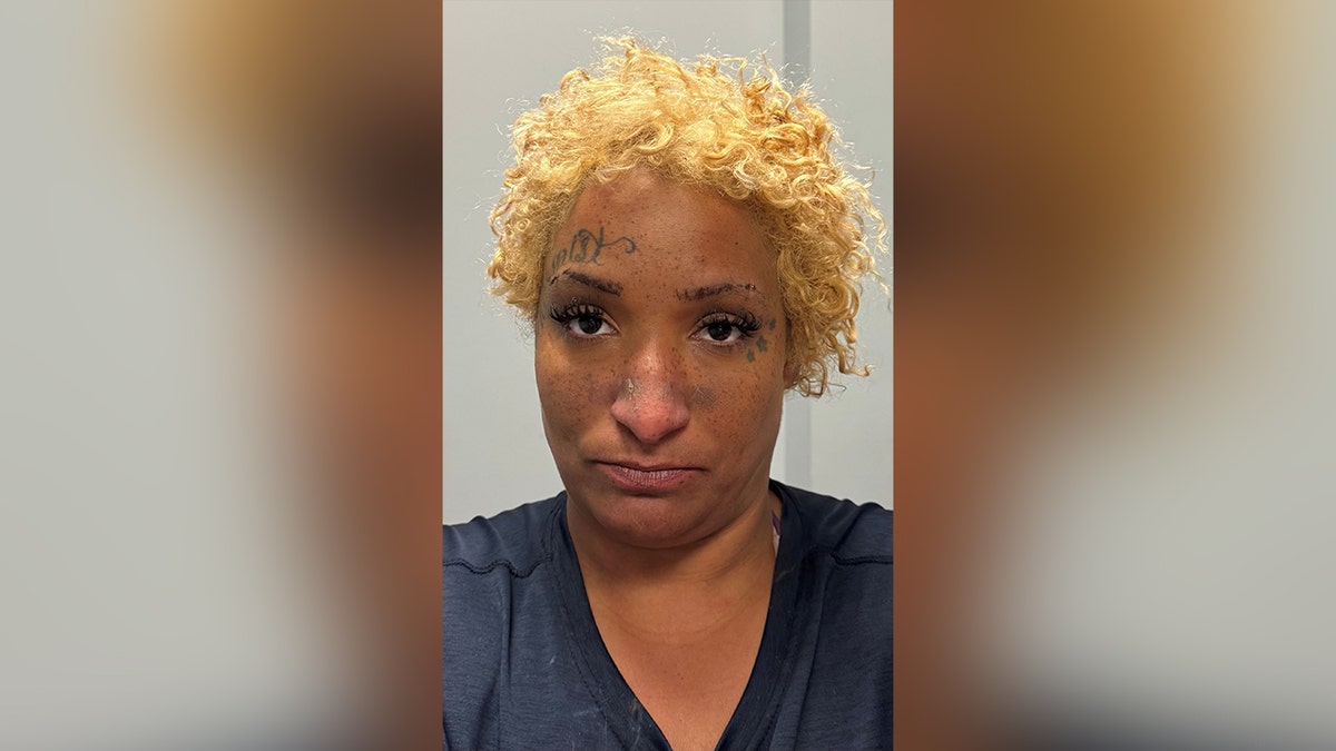 mugshot of blonde woman with face tattoos