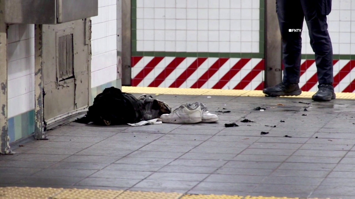 white sneakers and other belongings on the floor of the subway platform