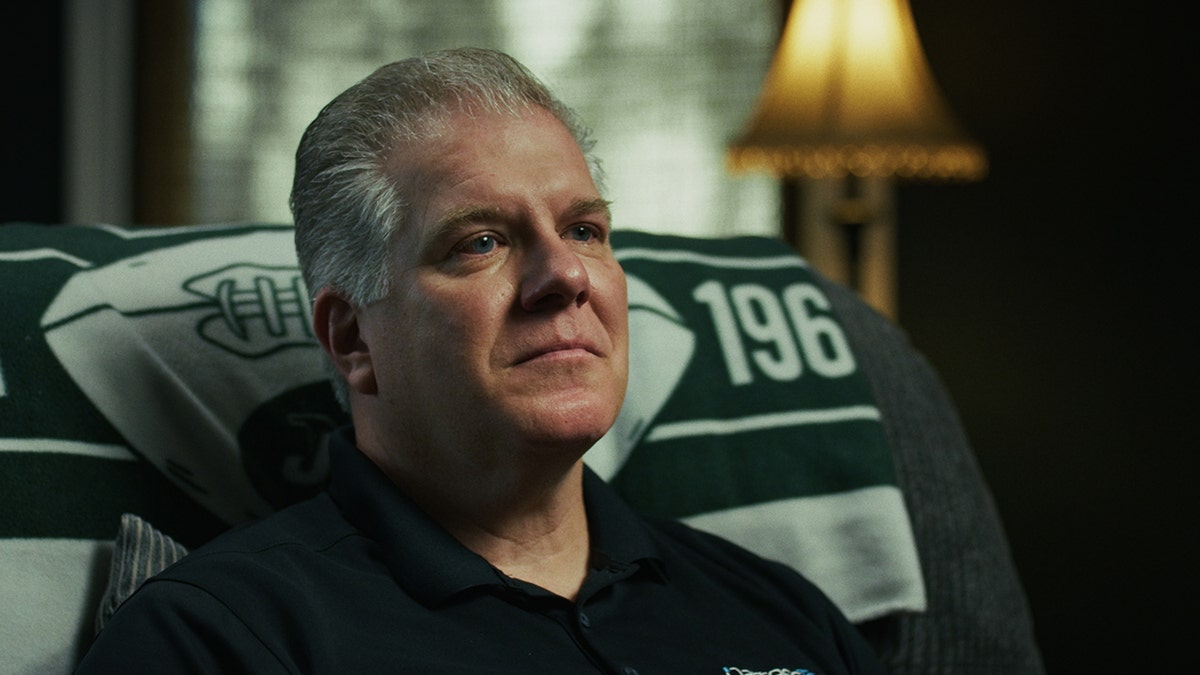 Shot of Rich Darress sitting back and looking thoughtful at his home, taken from his interview.