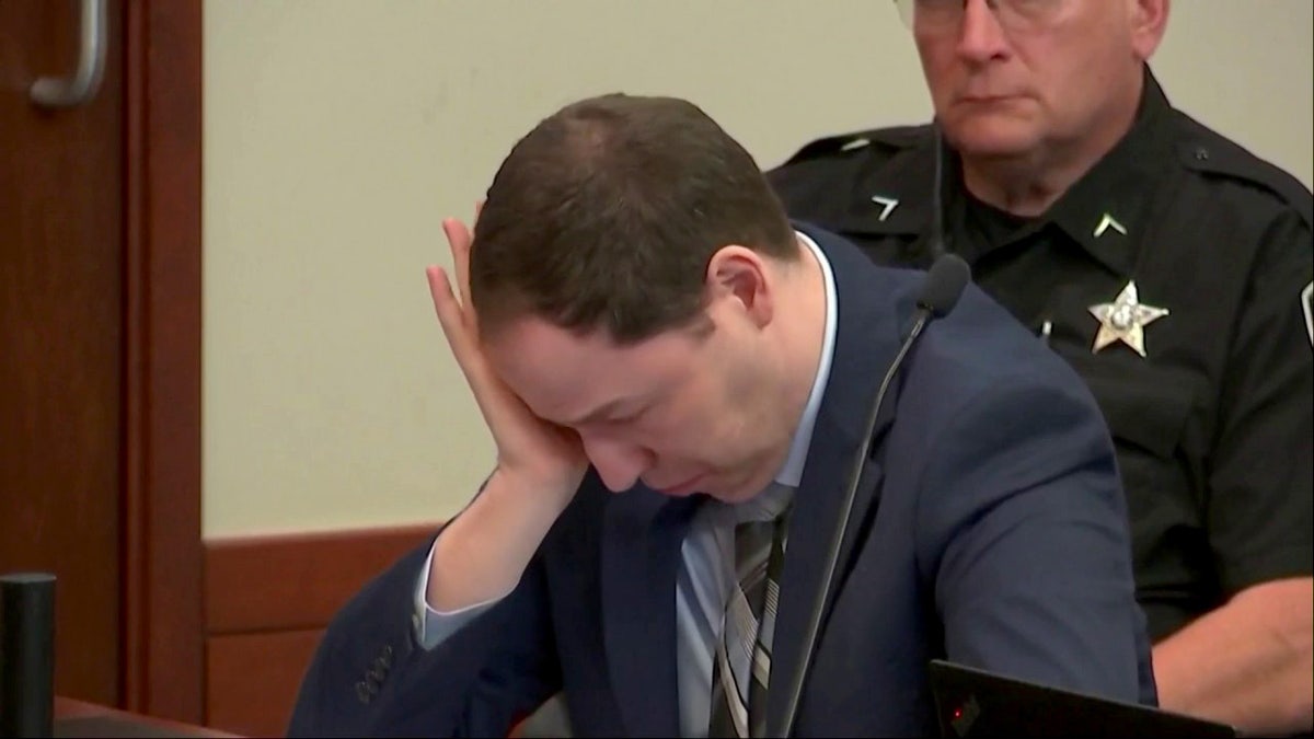 Brendan Banfield cries into his hand during his murder trial in Virginia.