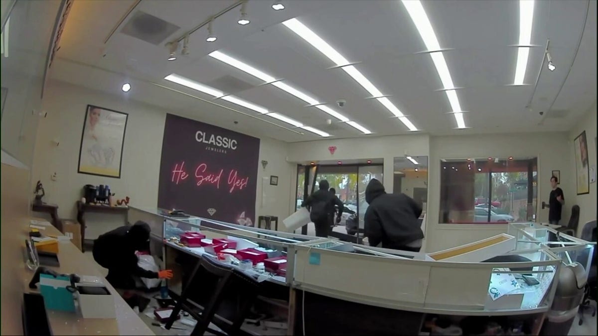 Men in masks looting the jewelry store. 