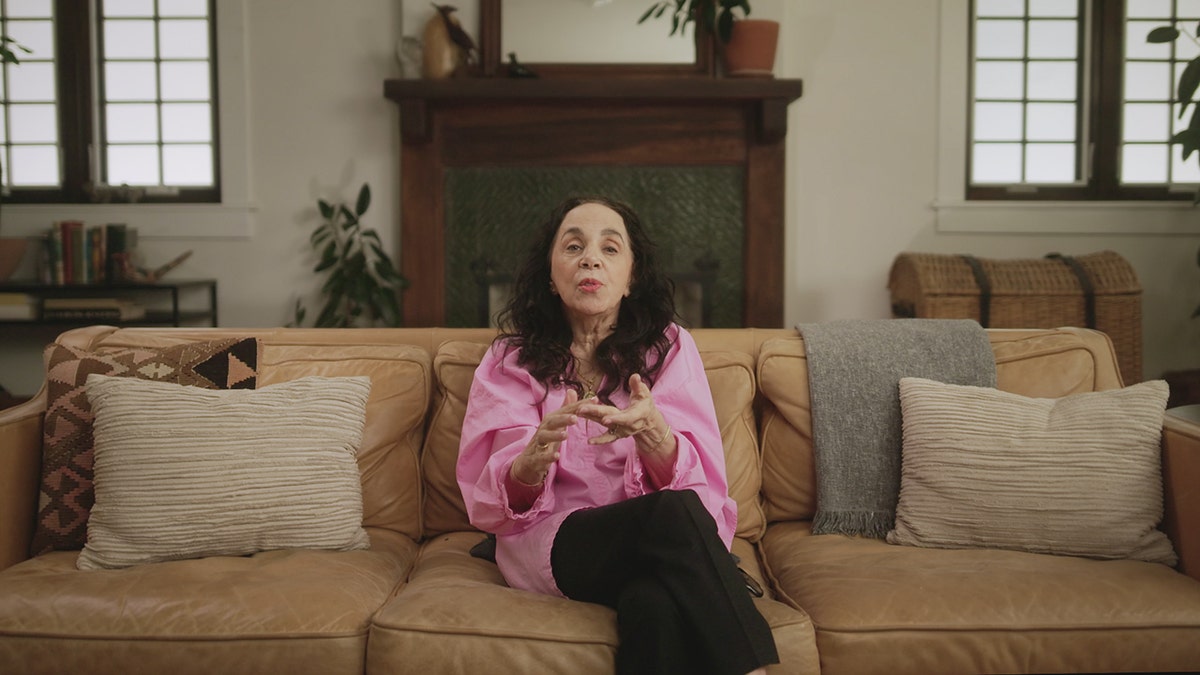 Laura Greenberg sitting in her couch speaking about Doug Gretzler.