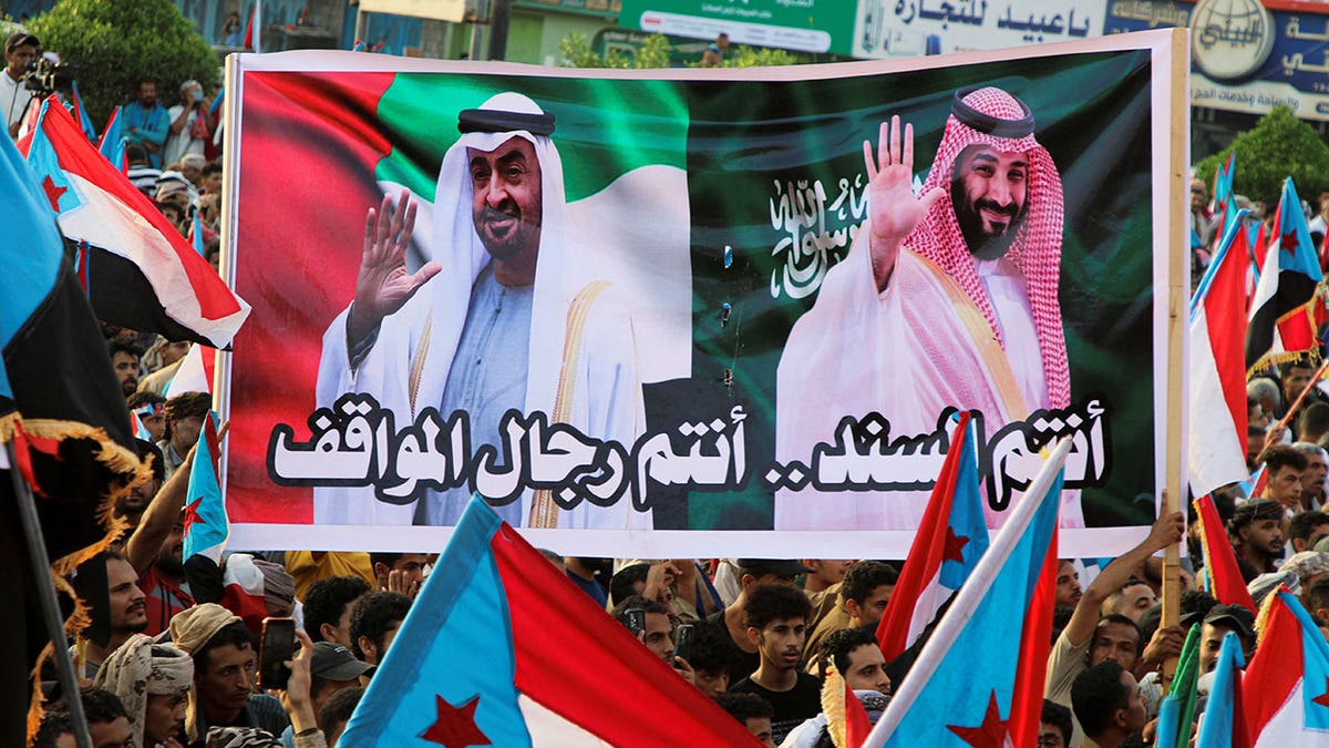 People hold a banner with images of the President of the United Arab Emirates, Sheikh Mohamed bin Zayed Al Nahyan, and Crown Prince and Prime Minister Mohammed bin Salman of Saudi Arabia during a rally organised by Yemen's main separatist group, the Southern Transitional Council (STC), in Aden, Yemen Dec. 21, 2025. 