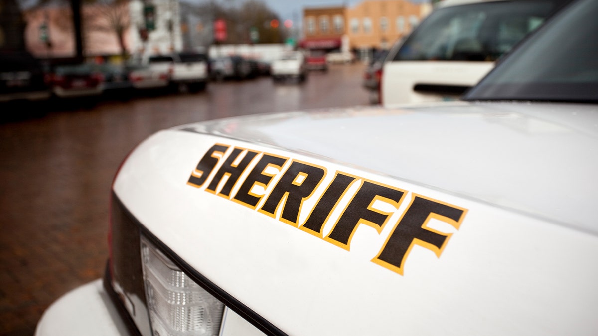 A car near a courthouse building along a town street.