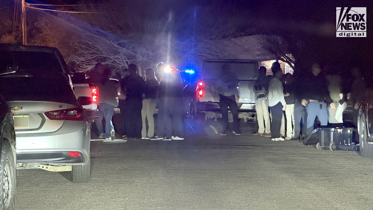 Law enforcement gather outside the house of a person of interest in the Nancy Guthrie case