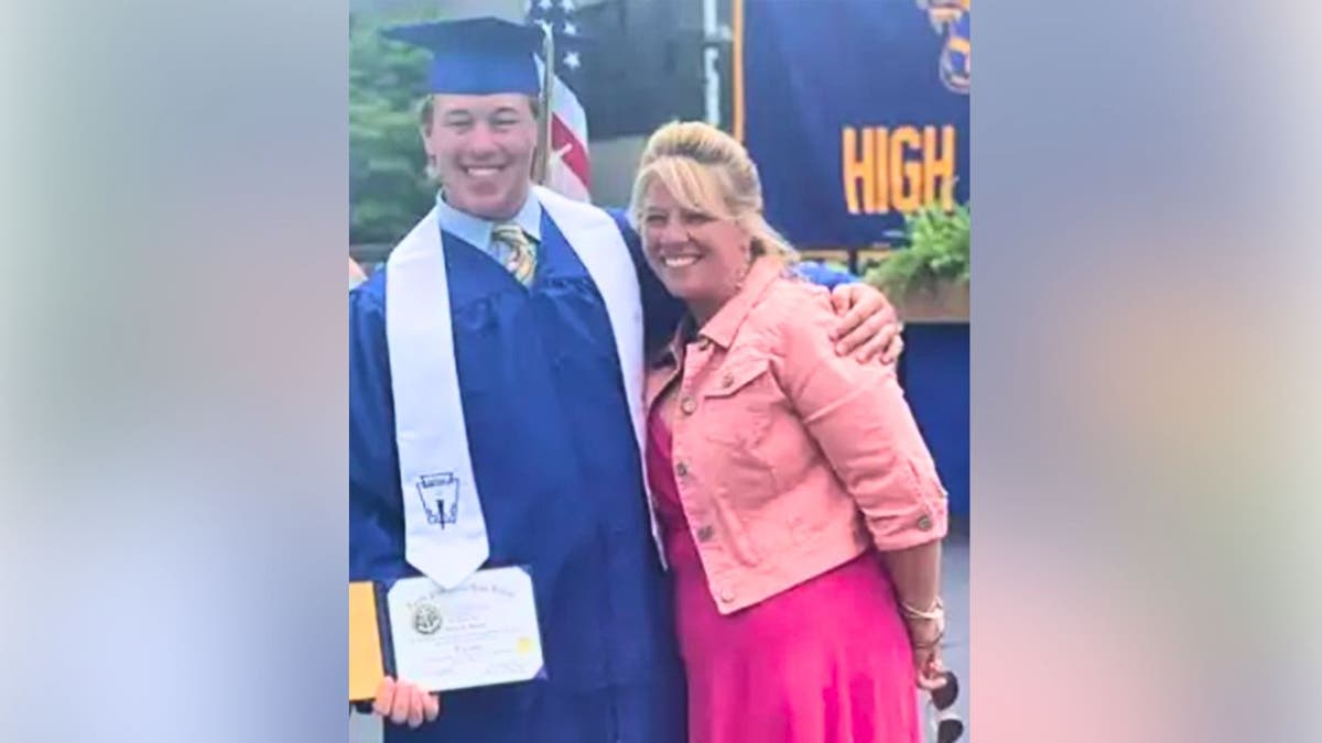 Aidan Dorgan in graduation cap and gown posing with his mother, Rhonda Dorgan, in a family photo.