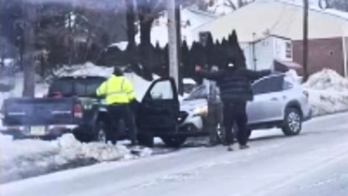ICE agent with gun drawn near crashed vehicles on a snowy roadside in New Jersey.