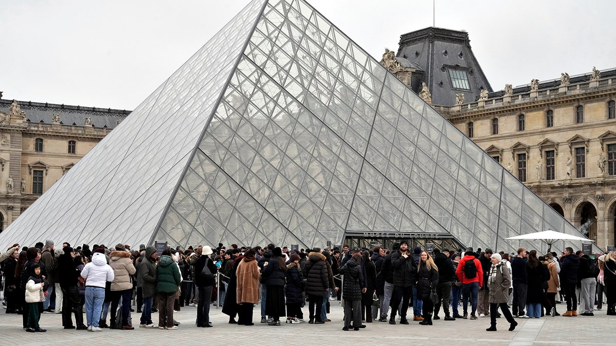 Louvre Museum exterior with people standing outside
