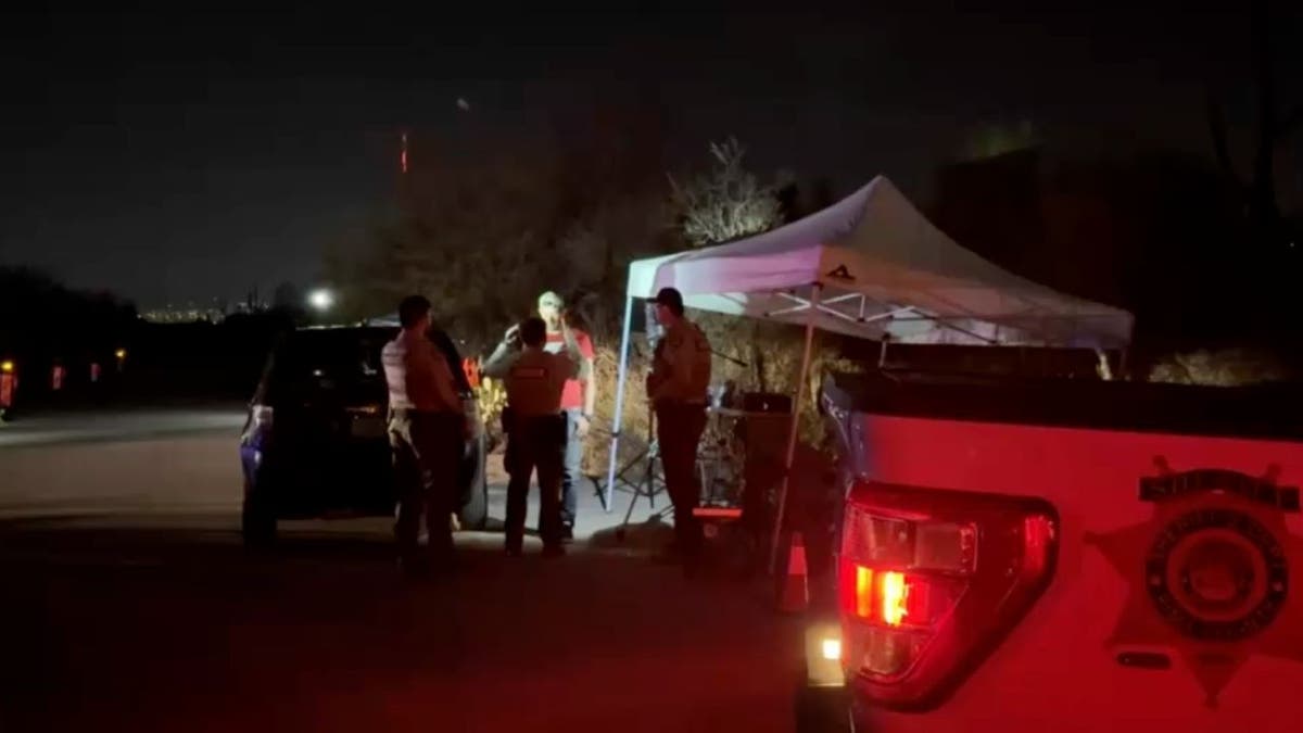 Deputies speaking with man near white canopy tent outside Nancy Guthrie home