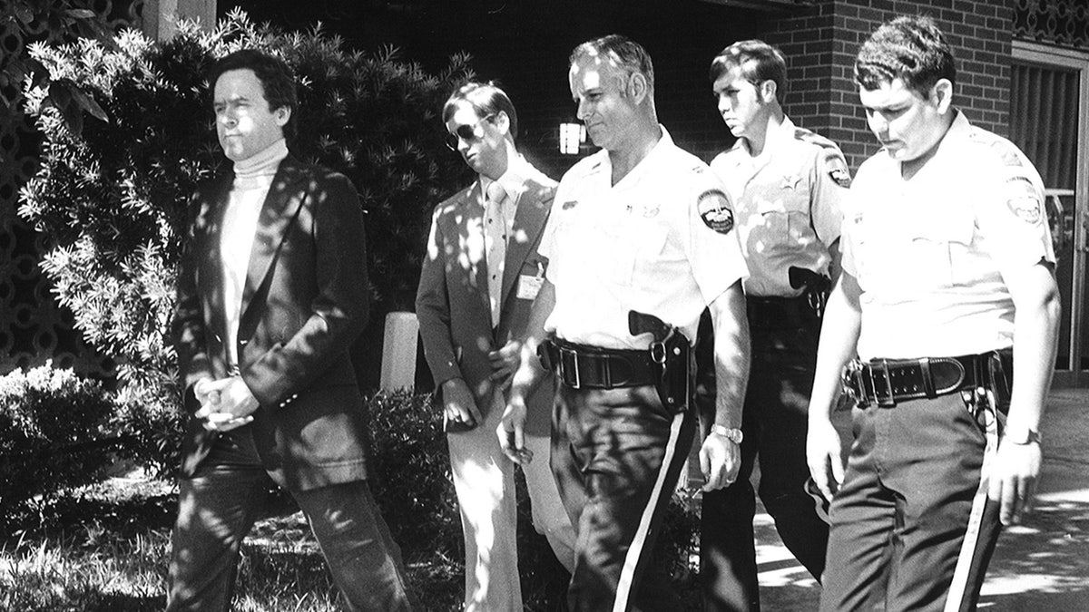 Ted Bundy being escorted by police.