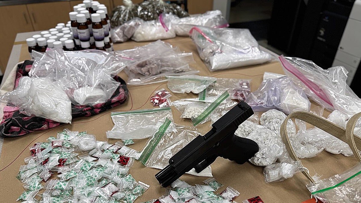 large amounts of drugs and gun on table